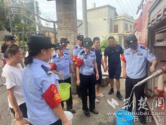 民輔警跟隨消防水車作業(yè)，通過肩挑手提的方式將清水送入行動(dòng)不便的老年、殘障村民的家中（通訊員 李麗君 攝） (3).jpg.jpg